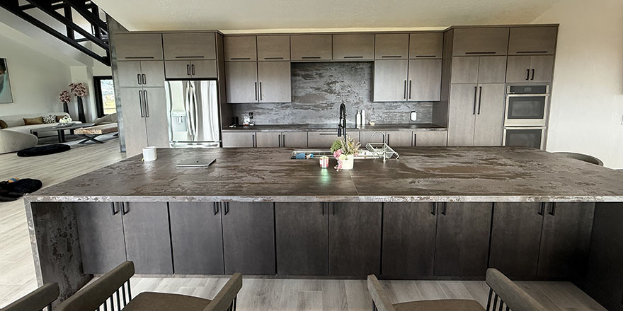Modern kitchen with navy blue cabinetry, stainless steel appliances, and a sink.