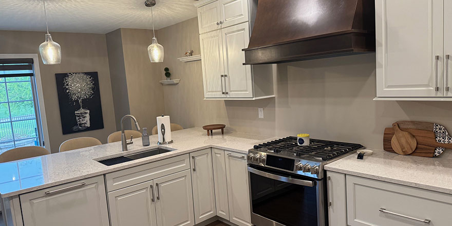 Bright kitchen with white cabinetry, a stainless steel refrigerator, and a coffee station beside the microwave.