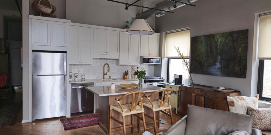 Modern kitchen with navy blue cabinetry, stainless steel appliances, and a sink.