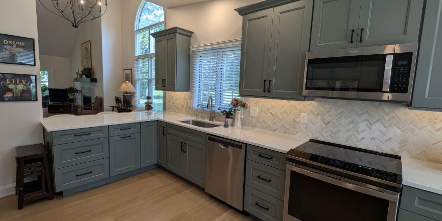 Bright kitchen with white cabinetry, a stainless steel refrigerator, and a coffee station beside the microwave.