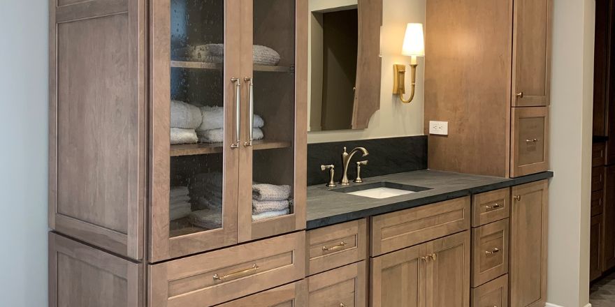 Modern kitchen with light gray cabinetry, a large island with seating, and stainless steel appliances.