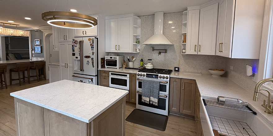 Bright kitchen with white cabinetry, a stainless steel refrigerator, and a coffee station beside the microwave.