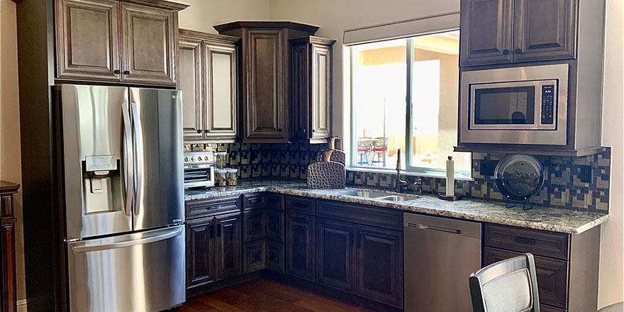 Modern kitchen with navy blue cabinetry, stainless steel appliances, and a sink.
