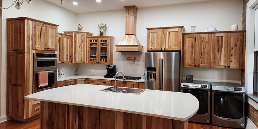 Bright kitchen with white cabinetry, a stainless steel refrigerator, and a coffee station beside the microwave.
