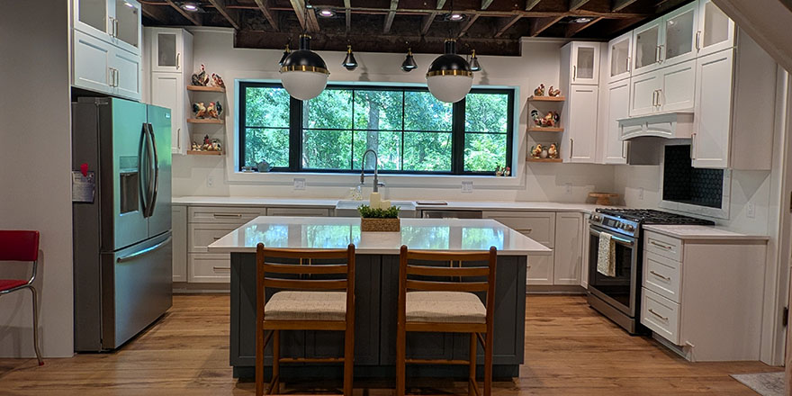 Bright kitchen with white cabinetry, a stainless steel refrigerator, and a coffee station beside the microwave.