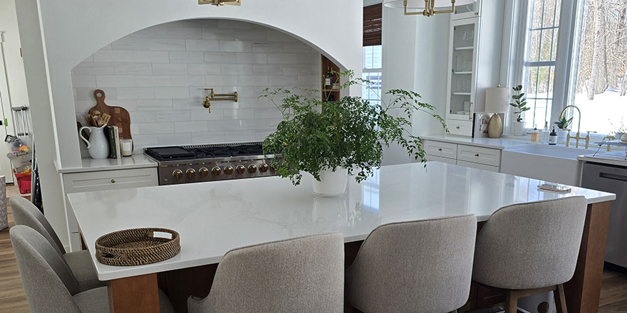 Modern kitchen with navy blue cabinetry, stainless steel appliances, and a sink.