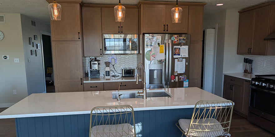 Bright kitchen with white cabinetry, a stainless steel refrigerator, and a coffee station beside the microwave.