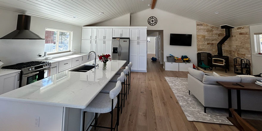 Modern kitchen with navy blue cabinetry, stainless steel appliances, and a sink.